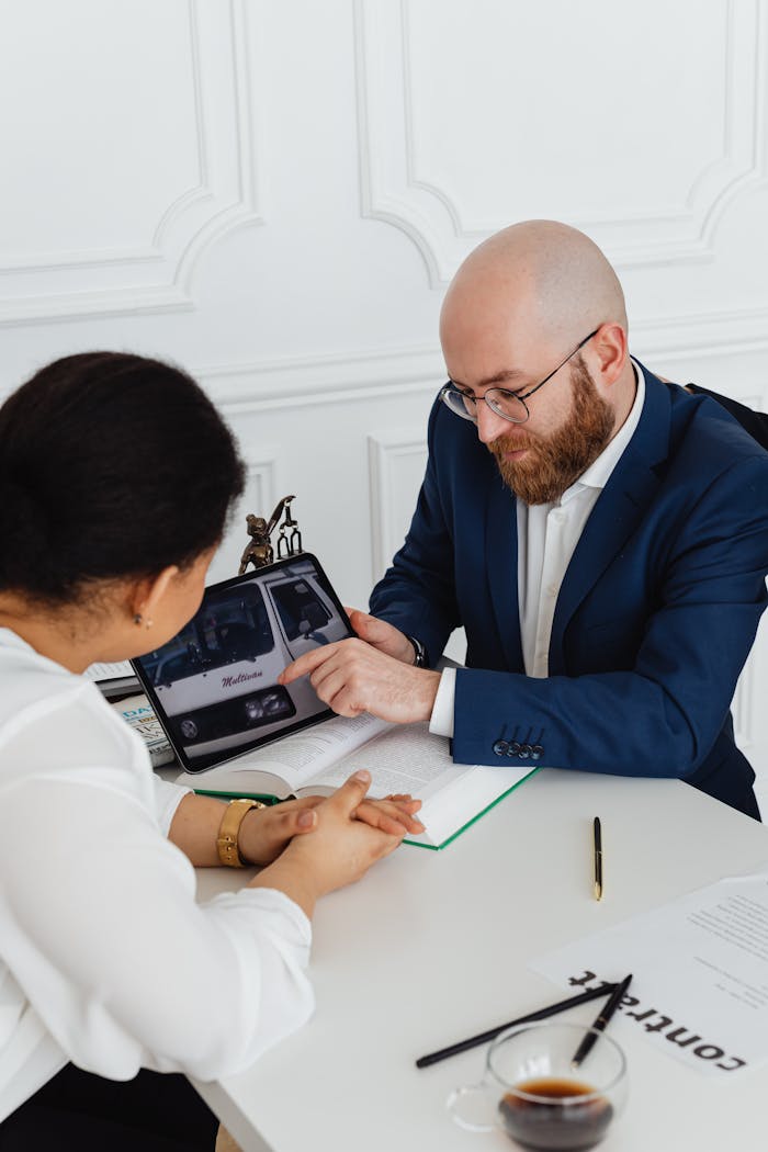 Two professionals discussing a project using a digital tablet in a modern office.